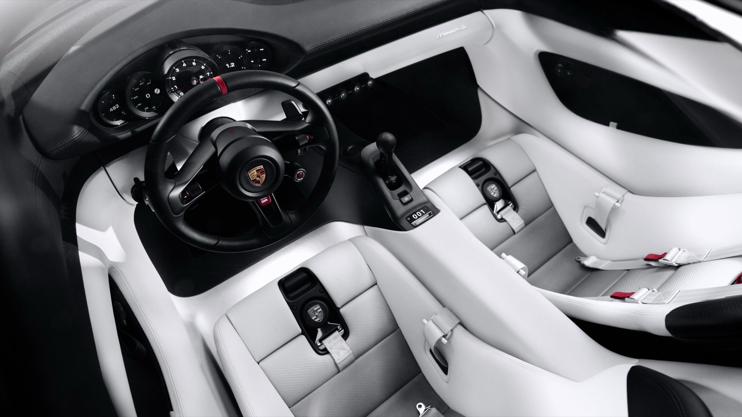 The cabin from above: black dashboard, white seats and door panels, and the centre console