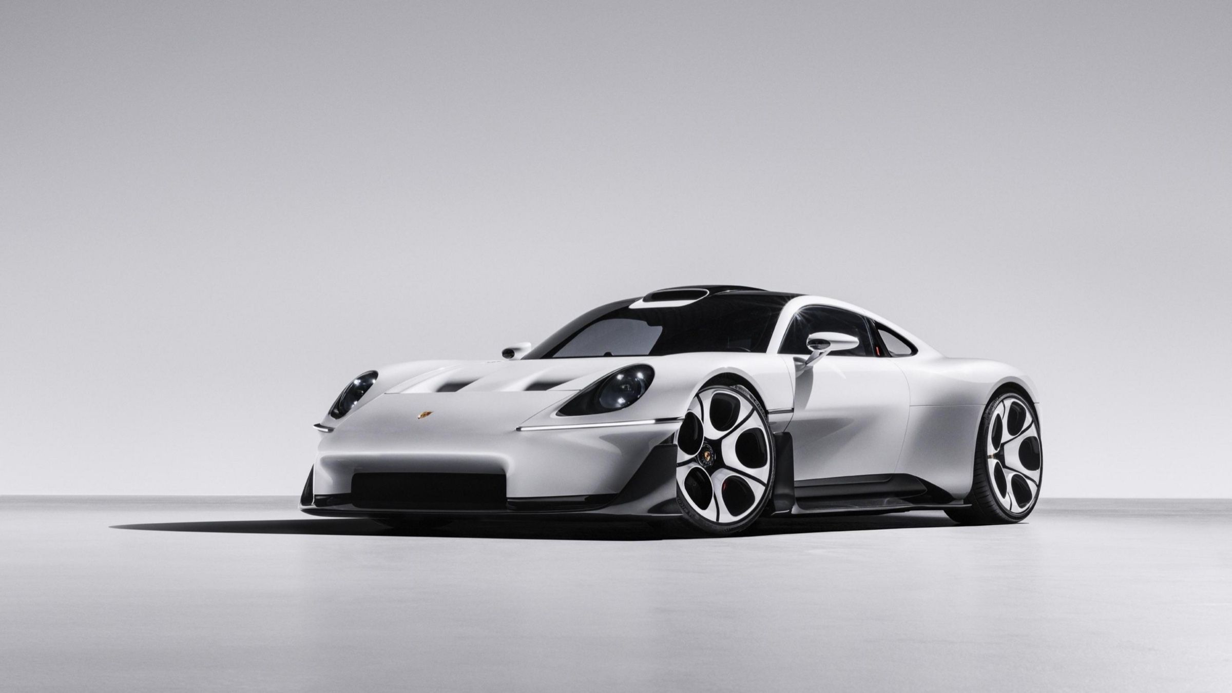 The white Mission S from the front three-quarter, showing round headlights, torpedo fenders and the low, wide stance