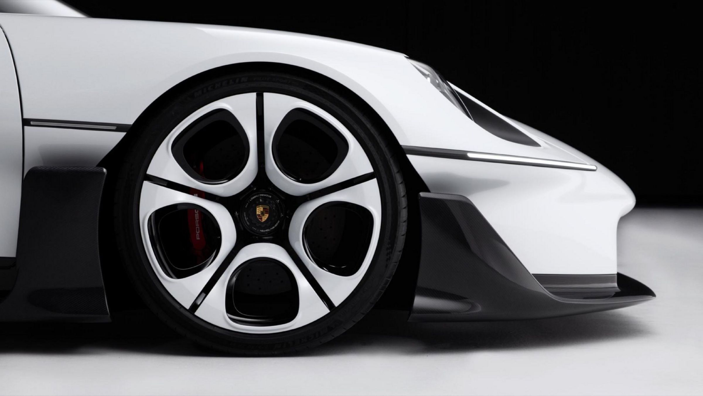 Close-up of the front wheel, a five-opening design with red brake calipers behind it