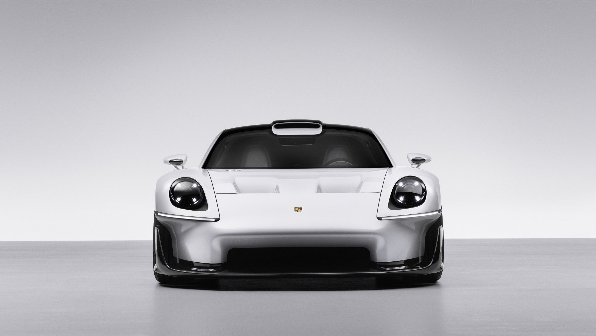 Head-on view of the flat front, the two round headlights and the Porsche crest on the nose