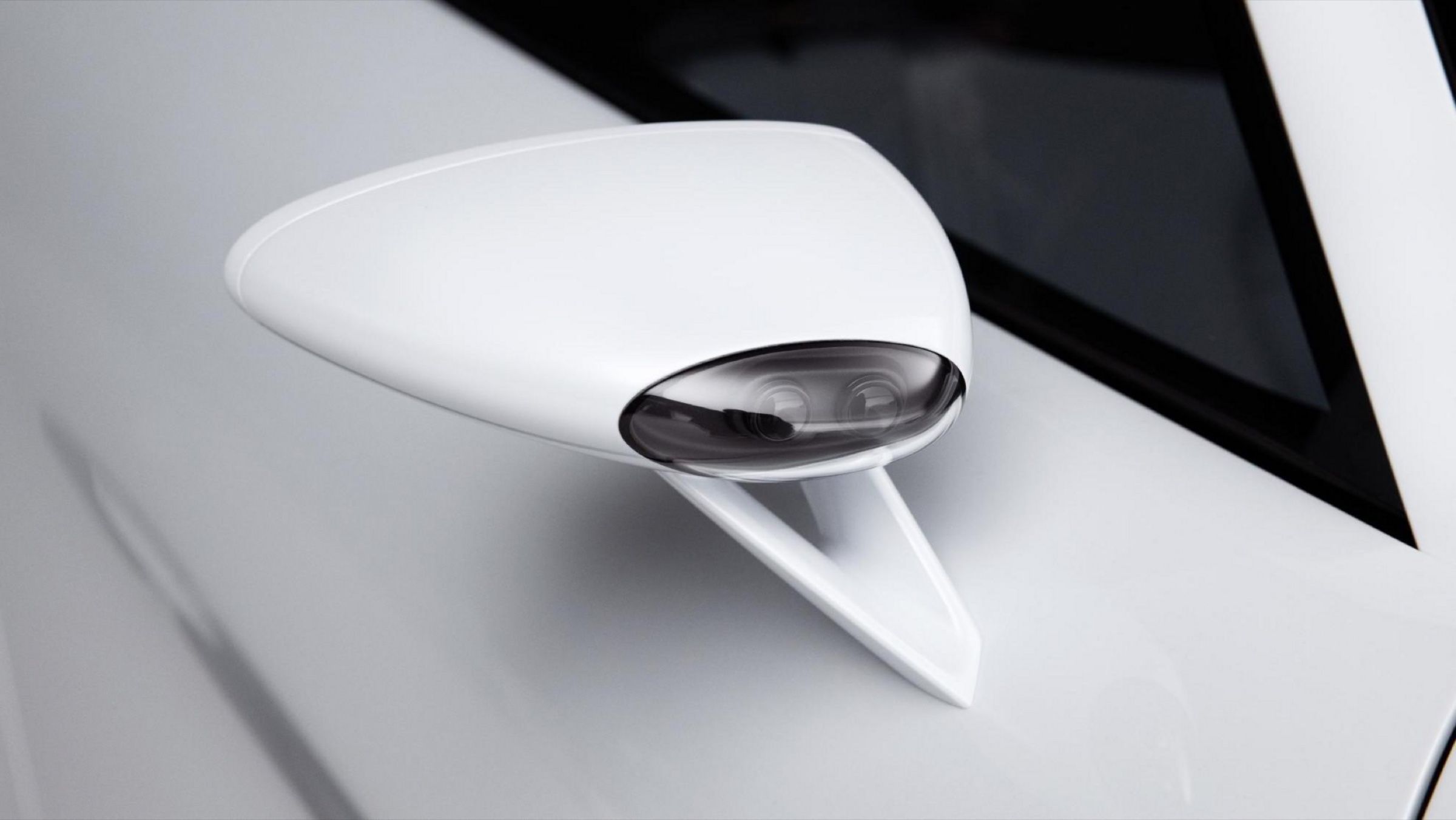 Close-up of the white sculpted door mirror on a thin stalk