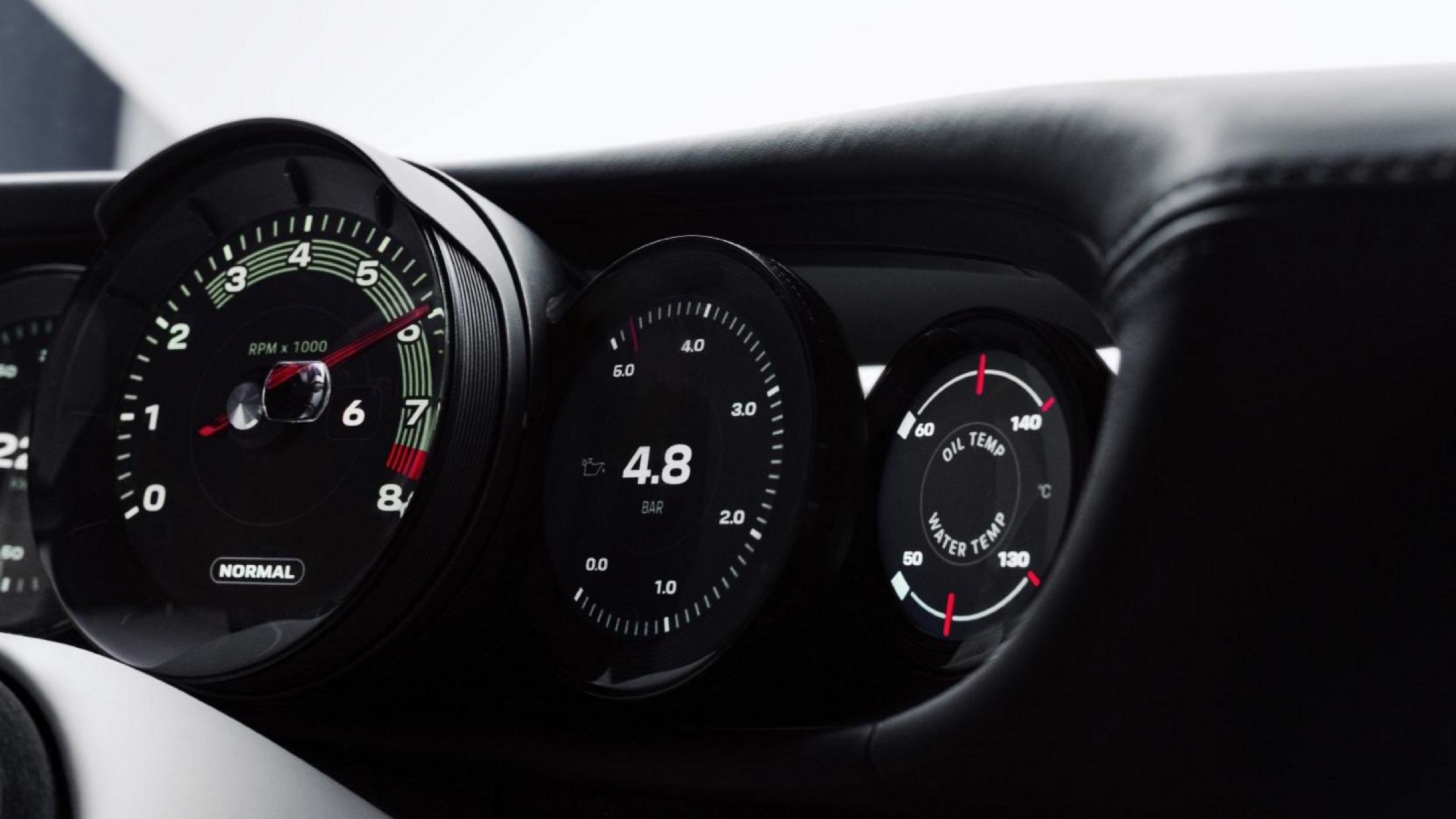 Close-up of the analogue rev counter needle and the gauges beside it