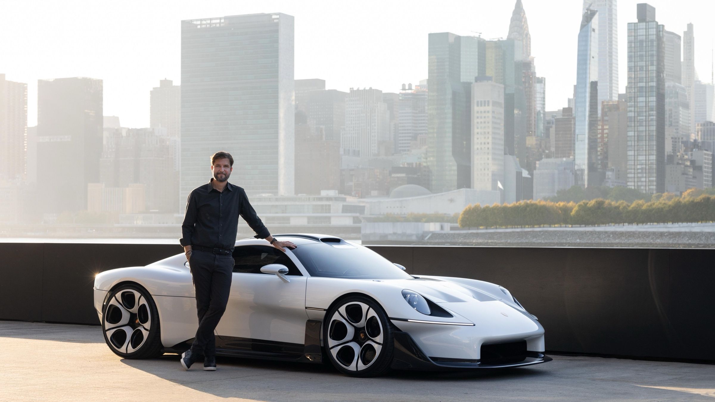 Tobias Sühlmann, Head of Style Porsche, standing beside the Mission S on the pier